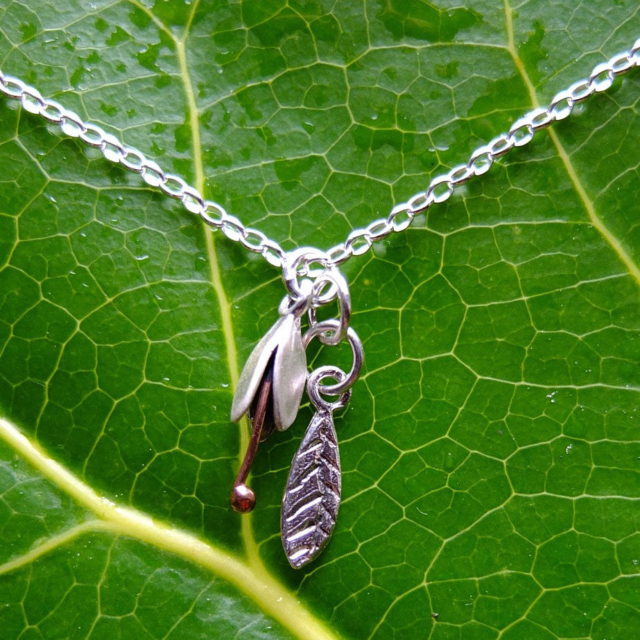 SIlver Bud and Leaf necklace. Small flower hangs over a silver leaf, by NZ jeweller Martyn Milligan, Rinopai, Golden Bay , Nelson.