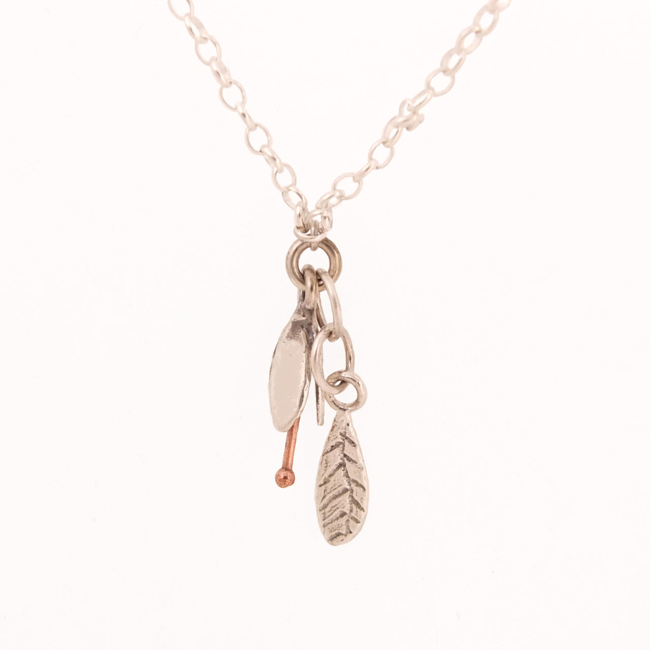 SIlver Bud and Leaf necklace. Small flower hangs over a silver leaf, by NZ jeweller Martyn Milligan, Rinopai, Golden Bay , Nelson.
