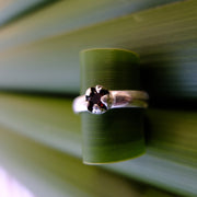Red Mānuka Ring sitting on a puka leaf | nz jewellery | Redmānuka sitting on a 